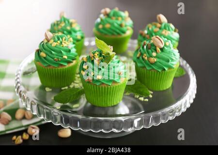 Cupcake al pistacchio e foglie di menta su supporto di vetro Foto Stock