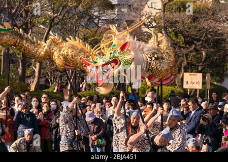 tokyo, giappone - marzo 18 2020: Maestri giapponesi di marionette che tengono un enorme drago d'oro per il tradizionale festival di danza dedicato al bodhisattva Kan Foto Stock