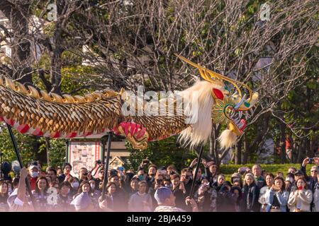 tokyo, giappone - marzo 18 2020: Maestri giapponesi di marionette che tengono un enorme drago d'oro per il tradizionale festival di danza dedicato al bodhisattva Kan Foto Stock