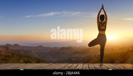 Giovane donna che pratica yoga nella felicità nature.female. Posa corpo equilibrio vitale zen e meditazione per l'allenamento natura montagna sfondo in morni Foto Stock