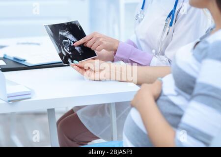 Donna incinta con il medico che guarda foto ultra suono in ospedale Foto Stock