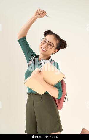 Bella studentessa che indossa zaino tenendo notebook su sfondo bianco isolato Foto Stock