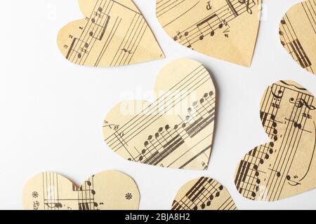 Cuori di carta con note su sfondo bianco, concetto musicale Foto Stock