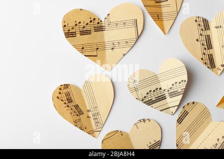 Cuori di carta con note su sfondo bianco, concetto musicale Foto Stock