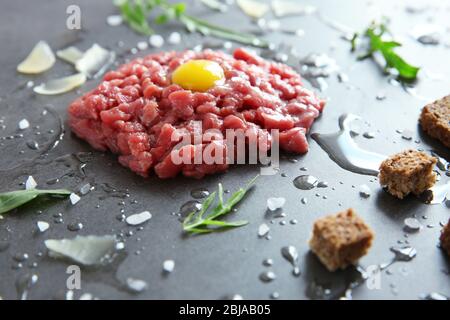 Bistecca di tartare con ingredienti su sfondo grigio Foto Stock