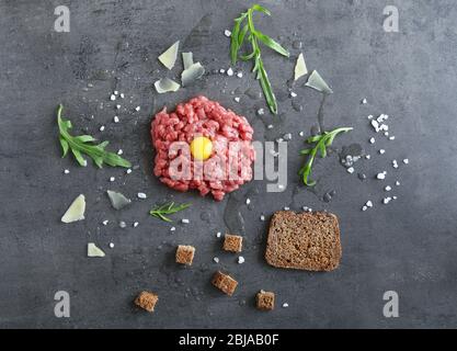 Bistecca di tartare con ingredienti su sfondo grigio Foto Stock