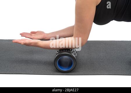 Una donna di mezza età su un rullo miofasciale fa un massaggio della mano su uno sfondo bianco. Foto Stock