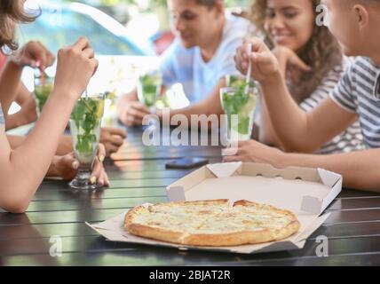 Amici che mangiano pizza al bar Foto Stock