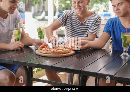 Happy amici di mangiare la pizza in cafe Foto Stock