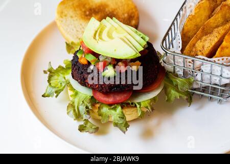 Hamburger vegani con barbabietole e fagioli serviti con verdure fresche. Foto Stock