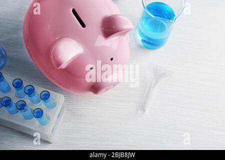 Scatola di denaro di maiale e acqua in tubi sul tavolo. Concetto di risparmio di acqua Foto Stock