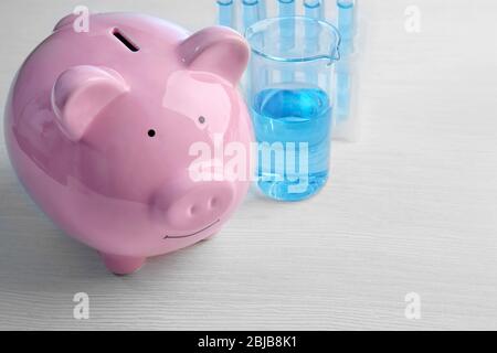 Scatola di denaro di maiale e acqua in tubi sul tavolo. Concetto di risparmio di acqua Foto Stock