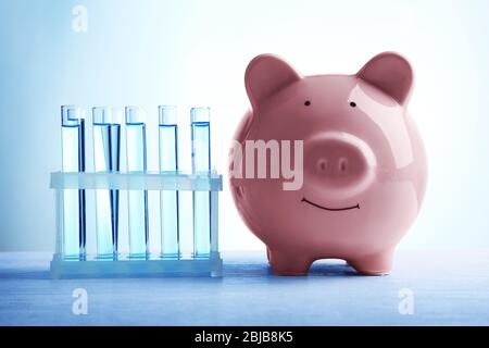 Scatola di denaro di maiale e acqua in tubi sul tavolo. Concetto di risparmio di acqua Foto Stock