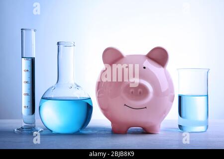 Scatola di denaro di maiale e acqua in tubi sul tavolo. Concetto di risparmio di acqua Foto Stock