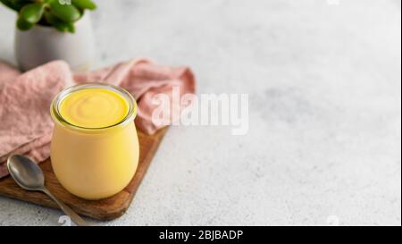 Giallo mango lassi su sfondo grigio. Indian Mango yogurt drink con copia spazio a sinistra. Foto Stock
