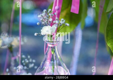 Mini vaso con fiori appesi su nastri esterni Foto Stock