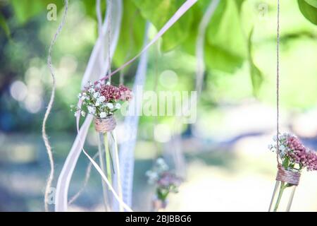 Mini vasi con fiori appesi su nastri esterni Foto Stock