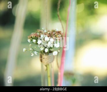 Mini vaso con fiori appesi su nastri esterni Foto Stock