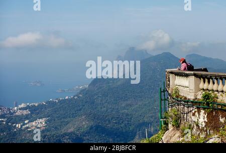 I turisti nelle aree di osservazione dello stato di Cristo Redentore sul monte Corcovado, guardando attraverso Rio de Janeiro, Brasile Foto Stock
