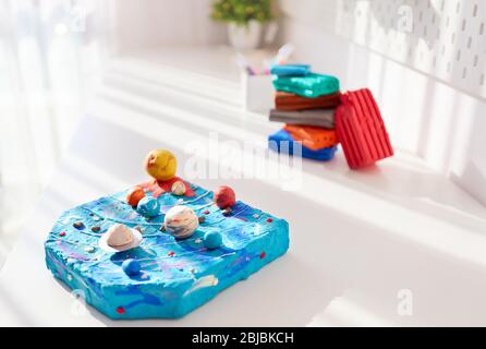 impianto solare realizzato a mano in plastilina dai bambini, sulla scrivania nella stanza dei bambini, progetto scolastico Foto Stock