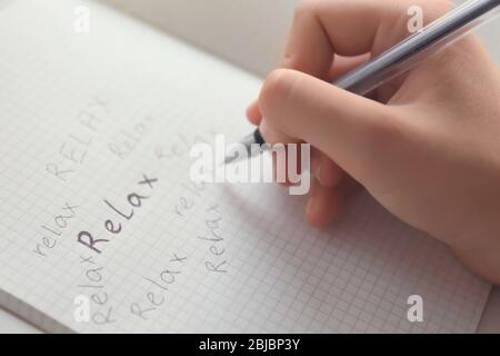 Parola di scrittura femminile "lax" nel notebook, vista ravvicinata Foto Stock