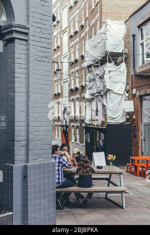 Londra/UK- 30/07/19: Una famiglia seduta al tavolo appena fuori dal pub Horseshoe su Heath Street a Hampstead. Ha alcuni dei più costosi hous Foto Stock