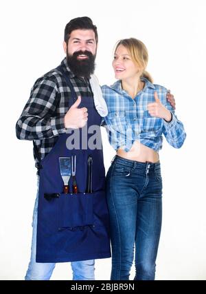Attrezzi per arrostire carne. Coppia in amore tenere utensili da cucina. Weekend per famiglie. Barbecue a picnic. Ricetta per cucinare cibo. Uomo barbuto ippico e ragazza. Preparazione e culinario. Motivo nel cibo. Foto Stock