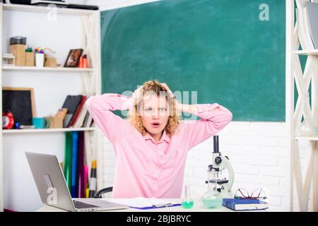 Concetto emotivo delle persone. Tutor donna o studente alla scrivania con computer portatile e cancelleria per le attrezzature scolastiche. Controllo emotivo. Educatore emotivo femminile insegnante in classe di sfondo lavagna. Foto Stock