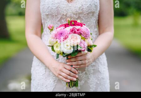 Bouquet di nozze nelle mani della sposa. Foto all'aperto Foto Stock