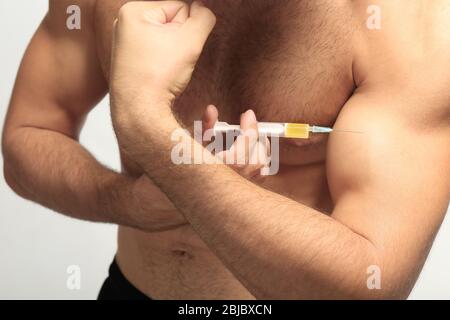 Uomo muscolare che inietta steroidi, primo piano Foto Stock