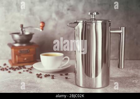 Macchina per il caffè, macinacaffè e tazza nuovi sul tavolo Foto Stock