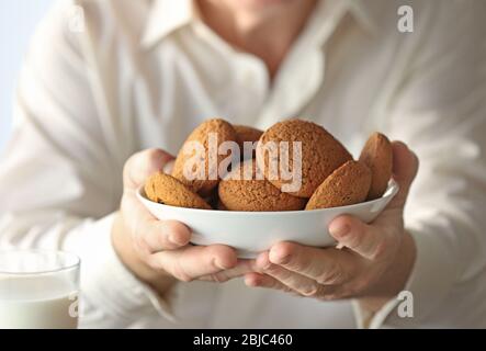 Senior man in possesso di una ciotola piena di biscotti Foto Stock