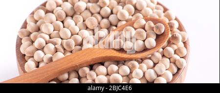 Perle di tapioca bruna cruda e secca in una ciotola di legno con cucchiaio isolato su sfondo bianco, primo piano, ingrediente di preparare tè al latte di bubble boca. Foto Stock