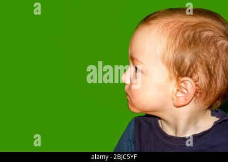 Bambino giovane con quasi tutti i capelli davanti a schermo verde Foto Stock