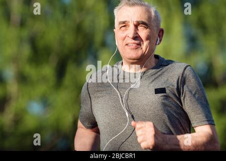 Ritratto uomo anziano settanta anni jogging all'alba. Corsa mattutina Foto Stock