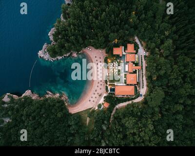 Budva, Montenegro - 10 giugno 2019: Banchetto di nozze, cena, al crepuscolo sotto la luce delle ghirlande. Tavoli al banchetto e un palco con un gruppo musicale Foto Stock