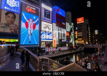 Vista notturna del famoso cartello dell'uomo da corsa Glico nel canale di Dotonbori, nel quartiere di Namba, Osaka, Giappone Foto Stock
