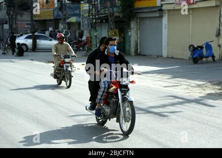 Islamabad, Pakistan. 29 aprile 2020. Un uomo che indossa una maschera facciale guida una moto durante il blocco come misura preventiva contro COVID-19 a Islamabad, capitale del Pakistan, il 29 aprile 2020. Credit: Ahmad Kamal/Xinhua/Alamy Live News Foto Stock