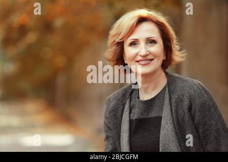 Ritratto di una splendida donna di mezza età nel parco autunnale Foto Stock