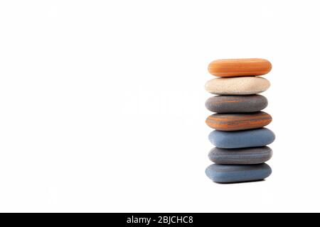 Un mucchio, pila, torre di pietre termali, trattamento semplice zen scena simbolo astratto, copia spazio sfondo. Gomma come ciottoli zen isolato su bianco Foto Stock