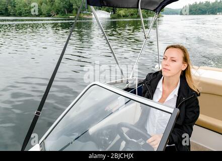 Giovane donna alla guida di un motoscafo Foto Stock