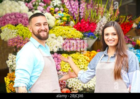 Fioristi maschi e femmine in negozio di fiori Foto Stock