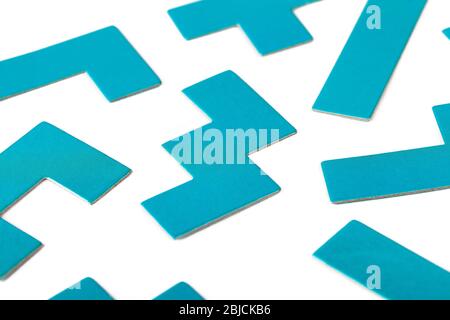 Varie forme, elementi puzzle blu, modello, sfondo bianco astratto. Parti disorganizzate sparse, figure scollegate diverse e semplici Foto Stock