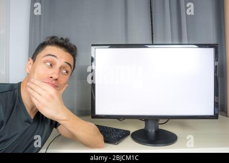 Uomo in camicia nera che punta a uno schermo del computer (copia spaziale) che annuncia notizie importanti. Primo piano. Foto Stock