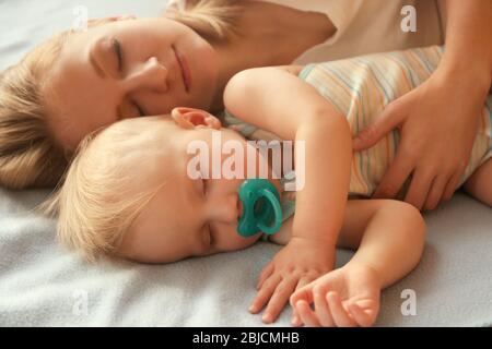 Bambino bambino ragazzo che dorme con la madre sul primo piano letto Foto Stock