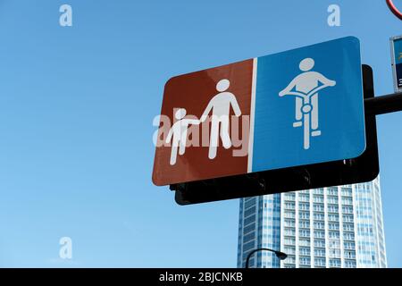 Il simbolo dell'adulto cammina per la mano di un cartello per bambini e di un cartello per la pista ciclabile con sfondi blu Foto Stock