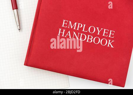 Manuale o manuale del dipendente con una penna e un foglio su un tavolo bianco in un ufficio - la politica di gestione del personale, spiega gli obiettivi aziendali, i risultati, definire Foto Stock