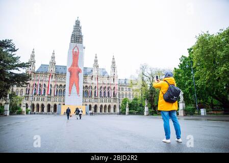 Vienna, Austria - 16 maggio 2019: uomo turistico viaggiatore che prende foto al telefono vienna City Hall sullo sfondo Foto Stock