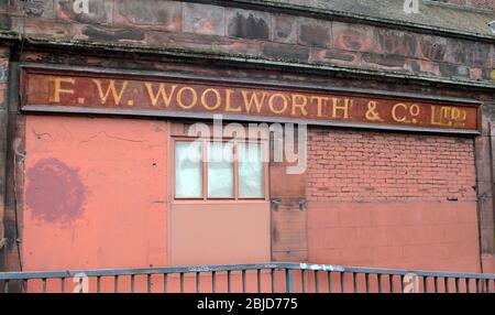 Un vecchio cartello F. W. WOOLWORTH & CO Ltd su un muro a Glasgow. Una delle più grandi catene di negozi al mondo, tutti i loro negozi in Gran Bretagna chiuse, per buona cosa, nel gennaio 2009. Tutto ciò che rimane, a Glasgow, della loro esistenza. Foto Stock