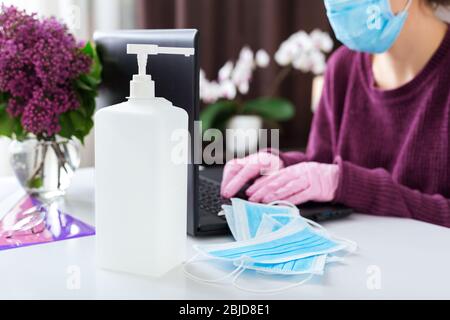Donna che lavora o impara da casa con un laptop durante Coronavirus, quarantena Covid-19 che indossa maschera protettiva medica.Freelancer Remote Work Foto Stock